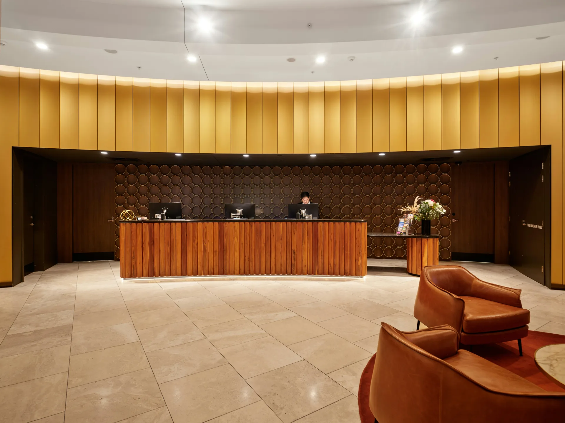 A hotel reception desk in warm wood and brass